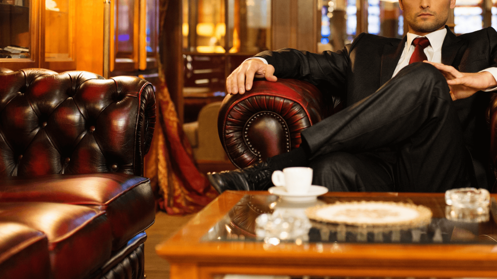 Man in a suit relaxing in a luxurious leather chair in a lounge.